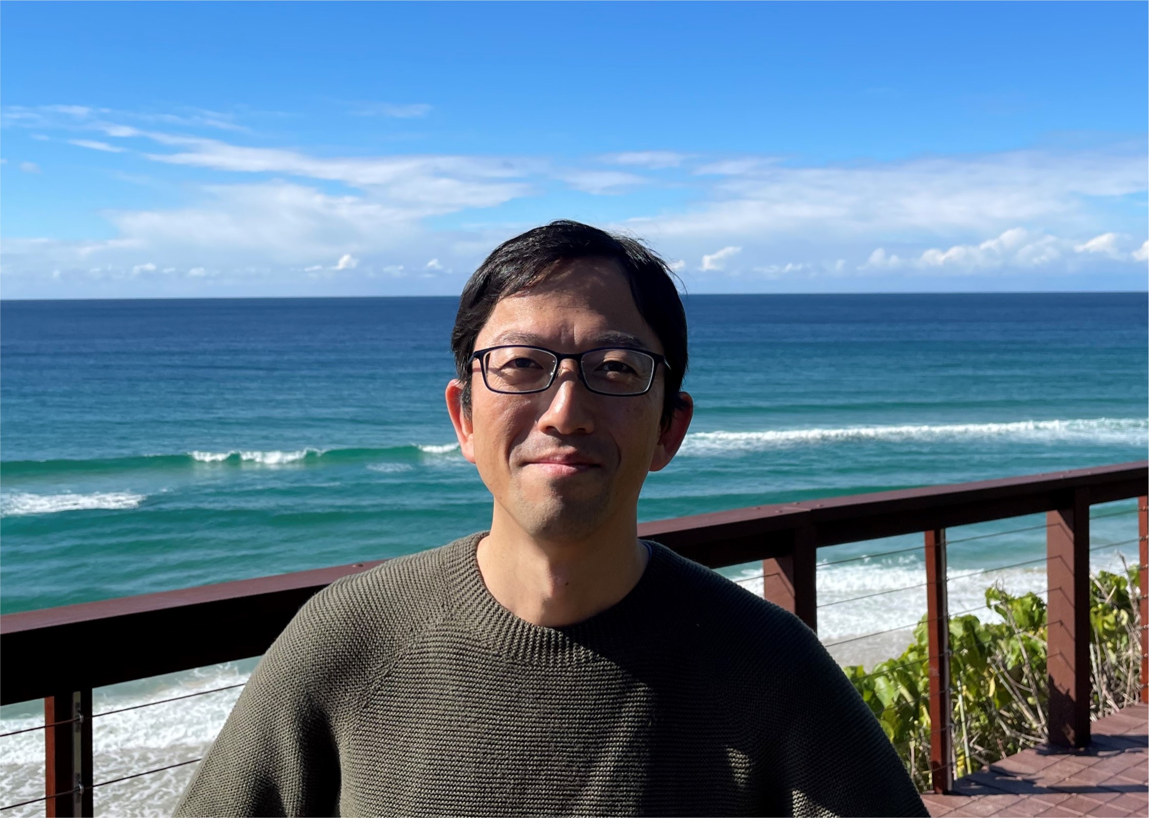 Tatsuya standing in front of a beach