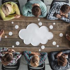 8 people sat brainstorming at a desk