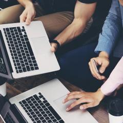 3 people using 2 laptops
