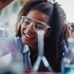 teenage girl wearing protective goggles doing experiment